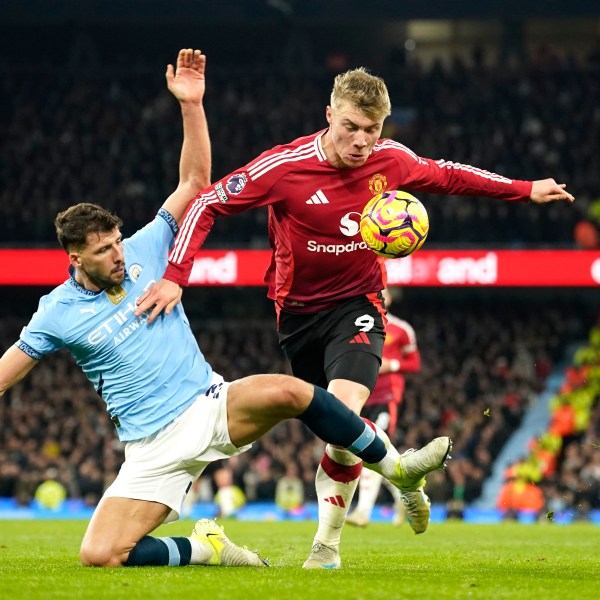 Manchester City's Ruben Dias, left, challenges for the ball with Manchester United's Rasmus Hojlund during the English Premier League soccer match between Manchester City and Manchester United at the Etihad Stadium in Manchester, Sunday, Dec. 15, 2024. (AP Photo/Dave Thompson)