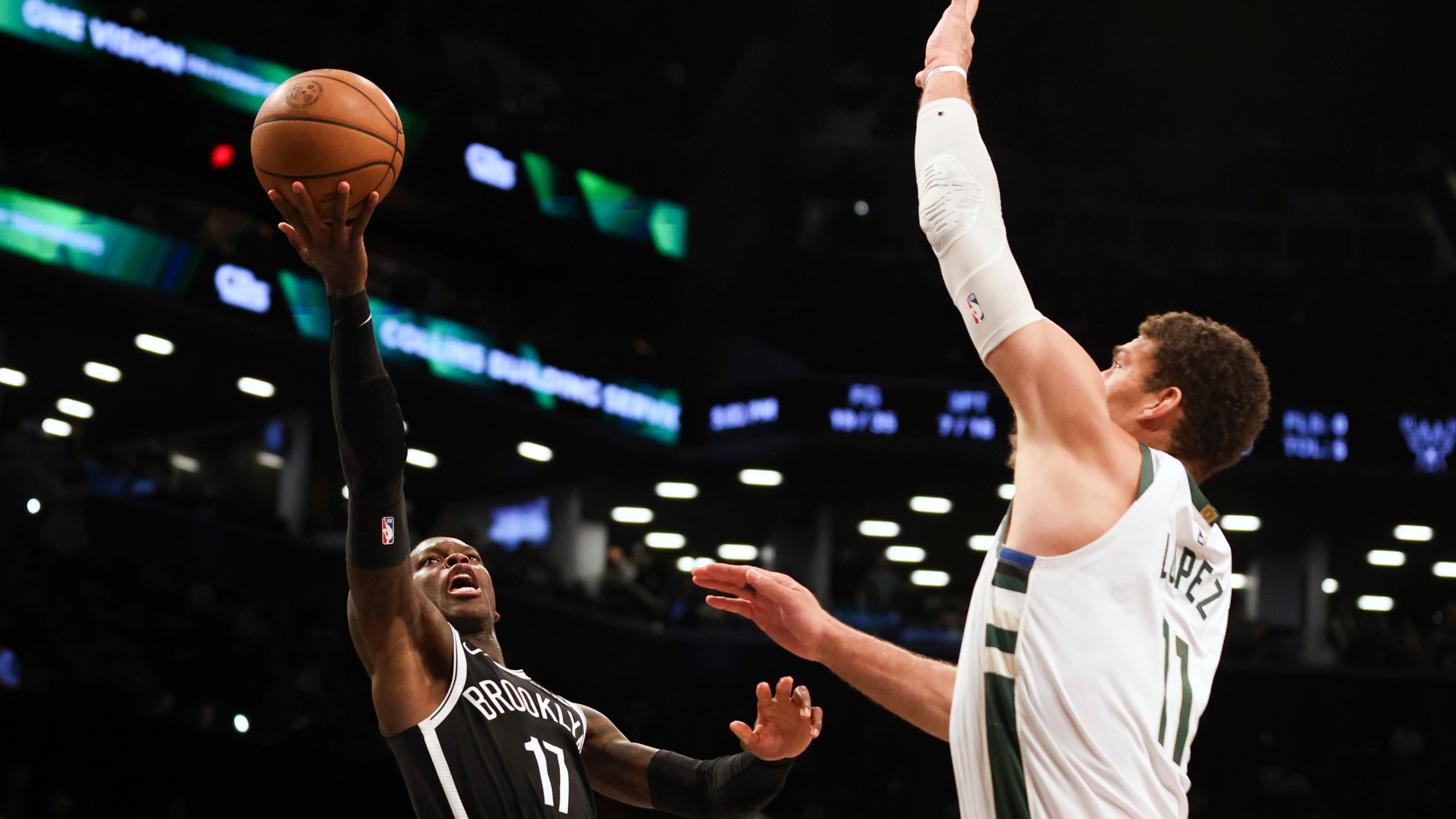 Brooklyn Nets' Dennis Schroder, left, looks to shoots over Milwaukee Bucks' Brook Lopez, right, during the second half of an NBA basketball game, Sunday, Dec. 8, 2024, in New York. (AP Photo/Heather Khalifa)