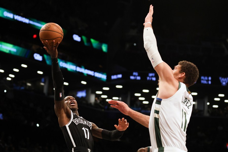 Brooklyn Nets' Dennis Schroder, left, looks to shoots over Milwaukee Bucks' Brook Lopez, right, during the second half of an NBA basketball game, Sunday, Dec. 8, 2024, in New York. (AP Photo/Heather Khalifa)