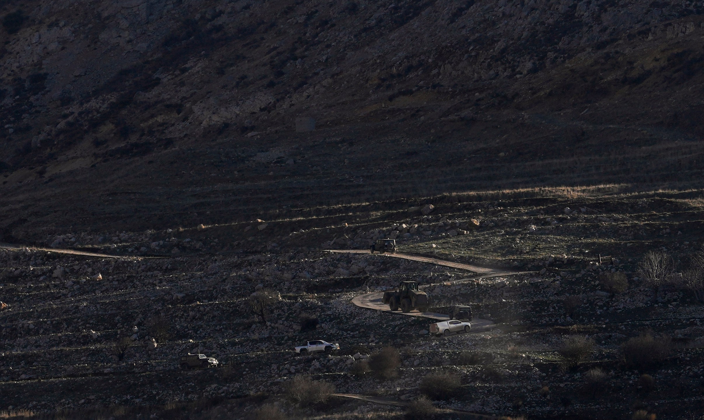 An Israeli bulldozer maneuvers on the buffer zone near the so-called Alpha Line that separates the Israeli-controlled Golan Heights from Syria, viewed from the town of Majdal Shams, Monday, Dec. 16, 2024. (AP Photo/Matias Delacroix)