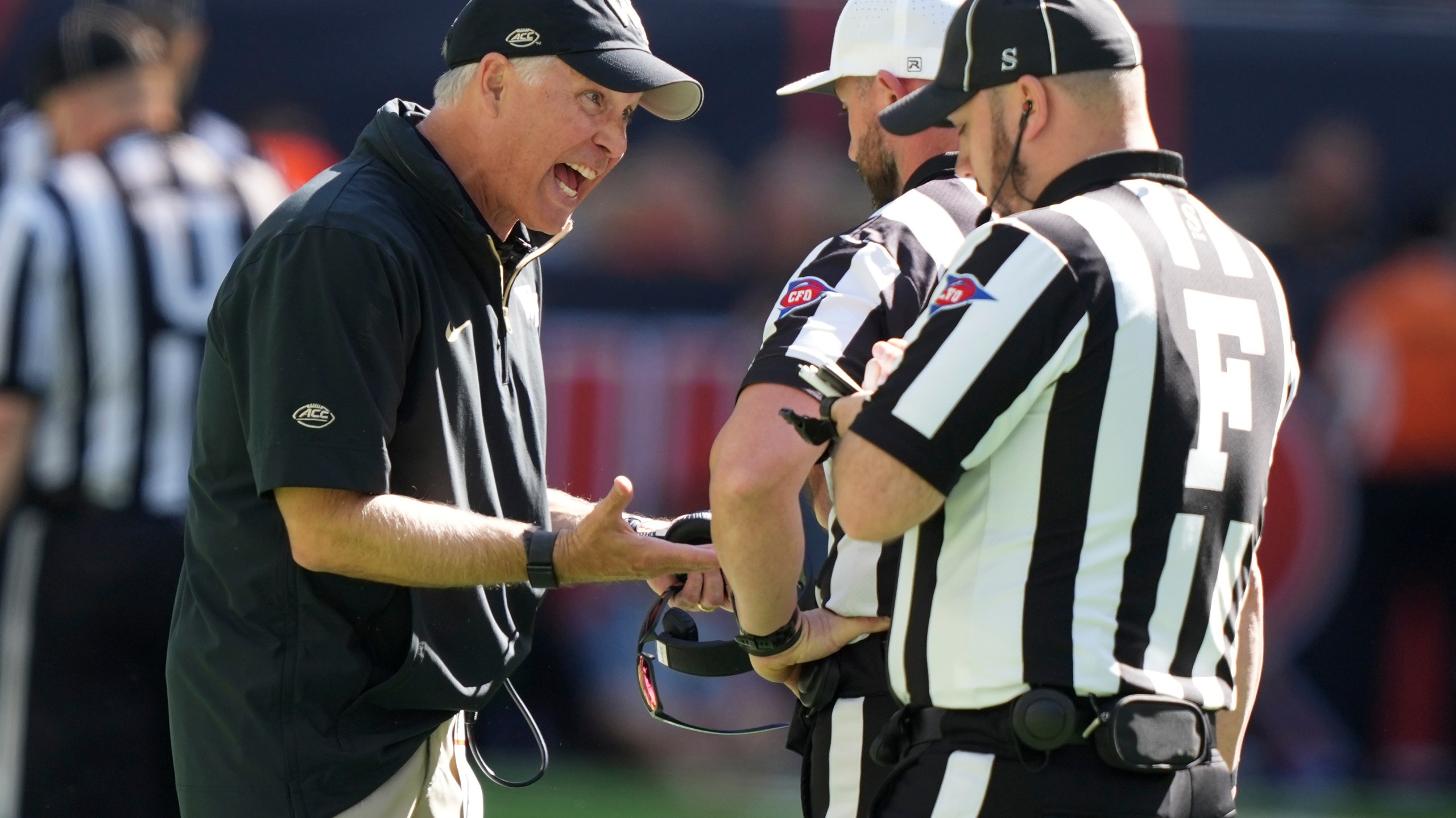 Wake Forest head coach Dave Clawson, left, talks with officials during the first half of an NCAA college football game against Miami, Saturday, Nov. 23, 2024, in Miami Gardens, Fla. (AP Photo/Lynne Sladky)