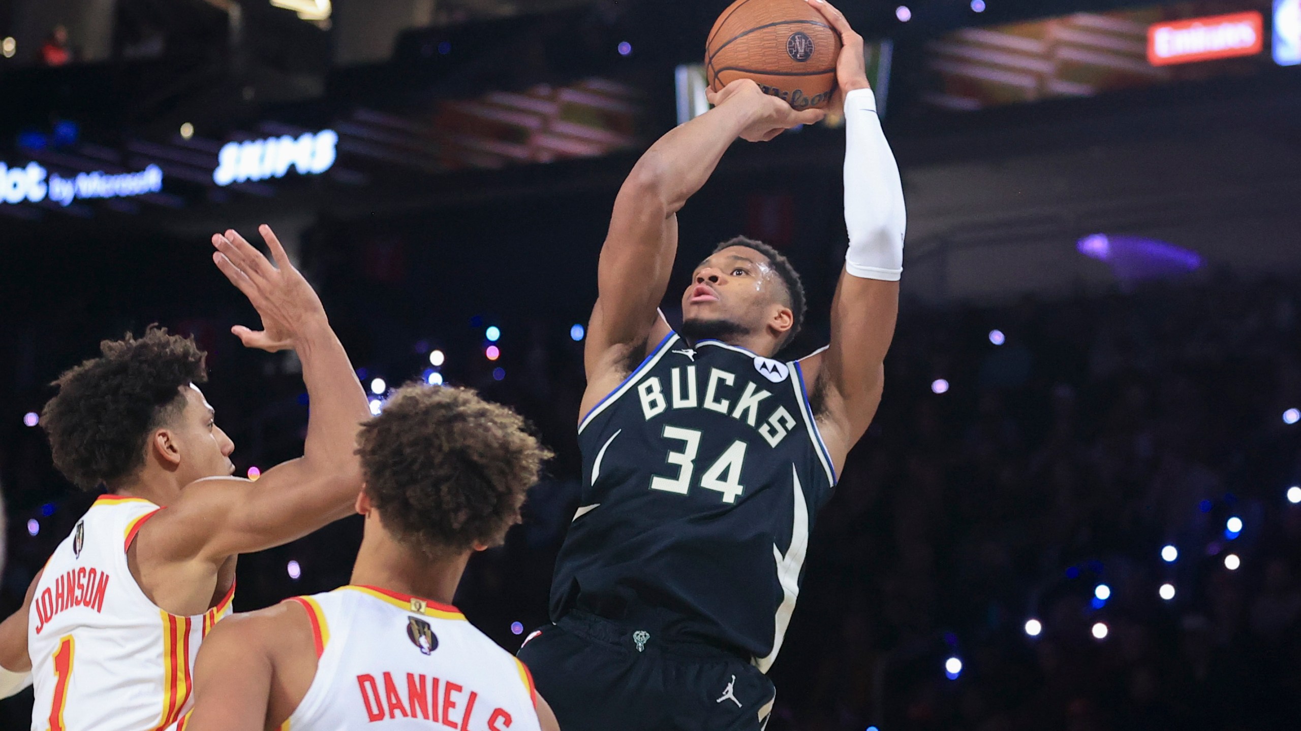 Milwaukee Bucks forward Giannis Antetokounmpo (34) goes up to shoot against Atlanta Hawks forward Jalen Johnson (1) and guard Dyson Daniels, second from left, during the second half of a semifinal game in the NBA Cup basketball tournament Saturday, Dec. 14, 2024, in Las Vegas. (AP Photo/Ian Maule)