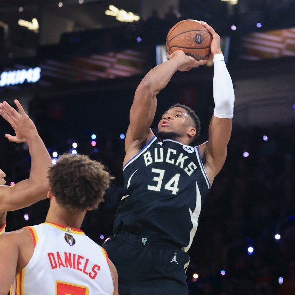 Milwaukee Bucks forward Giannis Antetokounmpo (34) goes up to shoot against Atlanta Hawks forward Jalen Johnson (1) and guard Dyson Daniels, second from left, during the second half of a semifinal game in the NBA Cup basketball tournament Saturday, Dec. 14, 2024, in Las Vegas. (AP Photo/Ian Maule)