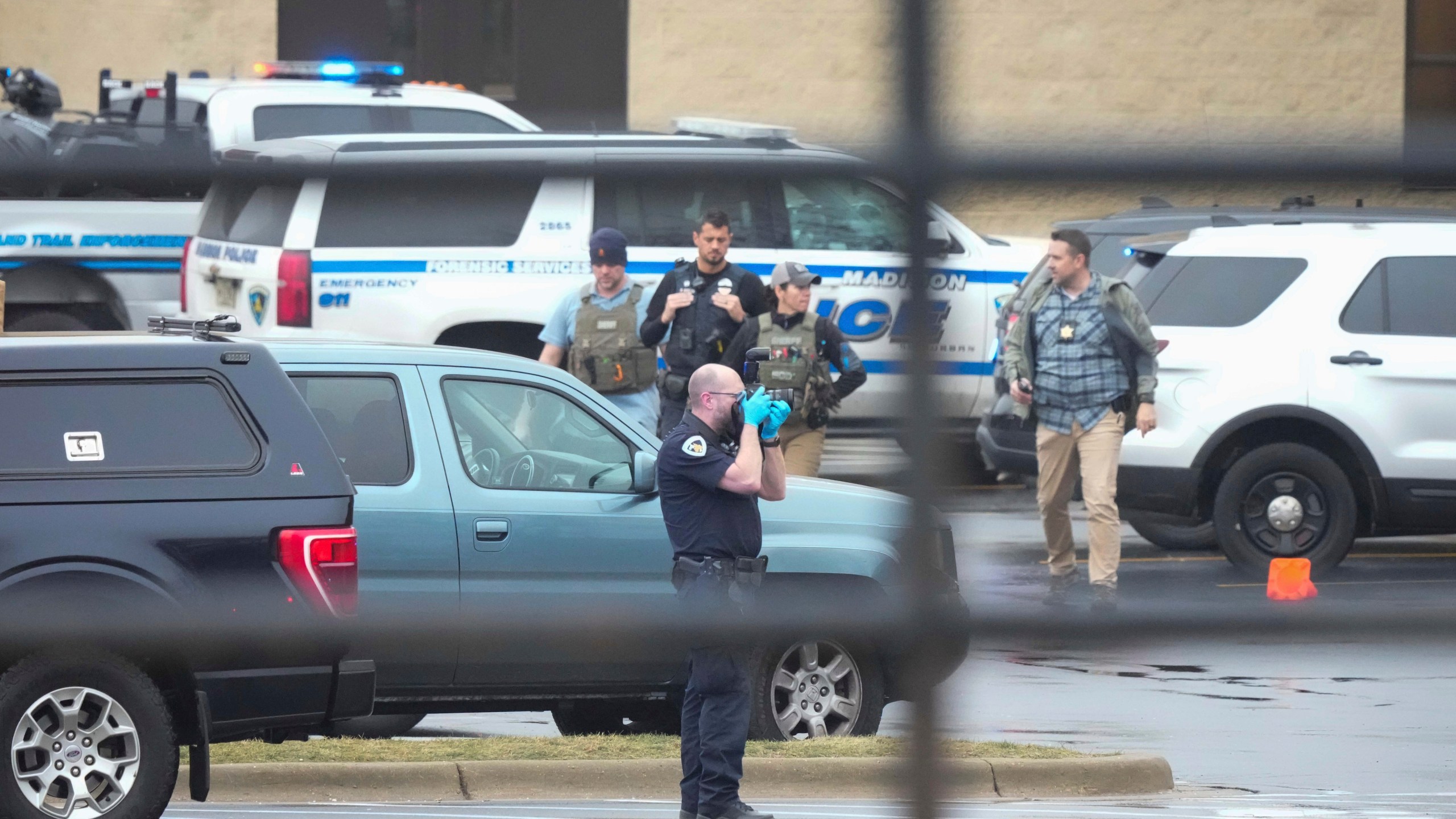 Police investigate as emergency vehicles are parked outside the Abundant Life Christian School in Madison, Wis., where multiple injuries were reported following a shooting, Monday, Dec. 16, 2024. (AP Photo/Morry Gash)