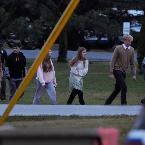 Students walk to a bus as they leave the shelter following a shooting at the Abundant Life Christian School, Monday, Dec. 16, 2024. (AP Photo/Morry Gash)