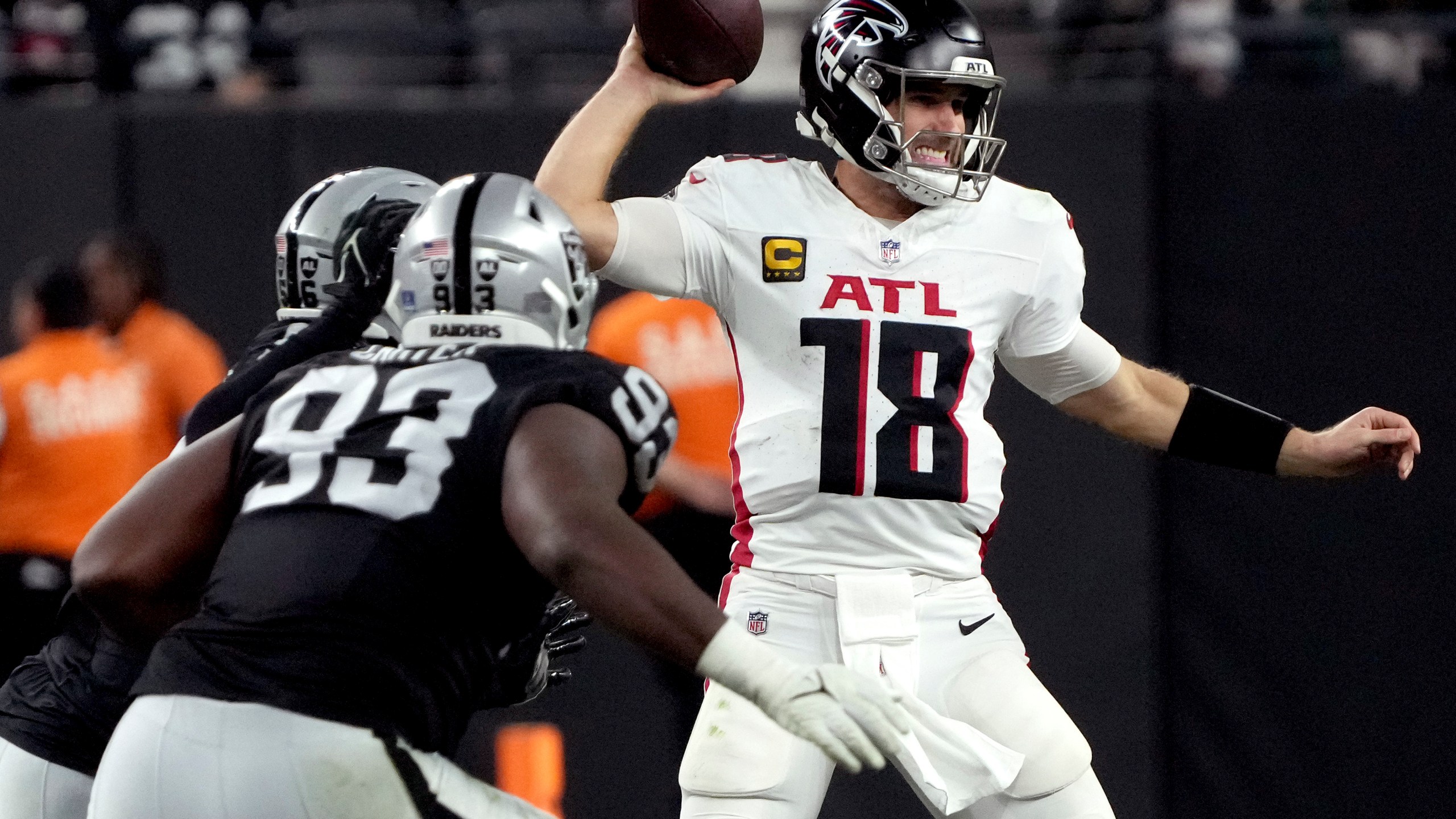 Atlanta Falcons quarterback Kirk Cousins (18) looks to throw as Las Vegas Raiders defensive tackle Zach Carter (93) pursues during the second half of an NFL football game, Monday, Dec. 16, 2024, in Las Vegas. (AP Photo/Rick Scuteri)