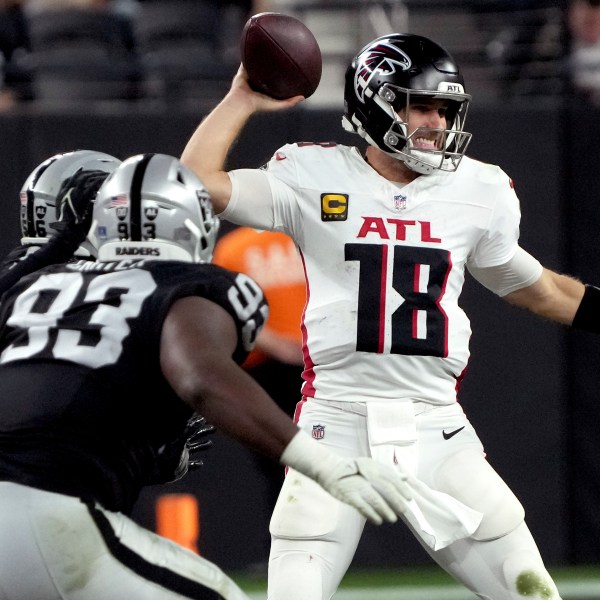 Atlanta Falcons quarterback Kirk Cousins (18) looks to throw as Las Vegas Raiders defensive tackle Zach Carter (93) pursues during the second half of an NFL football game, Monday, Dec. 16, 2024, in Las Vegas. (AP Photo/Rick Scuteri)