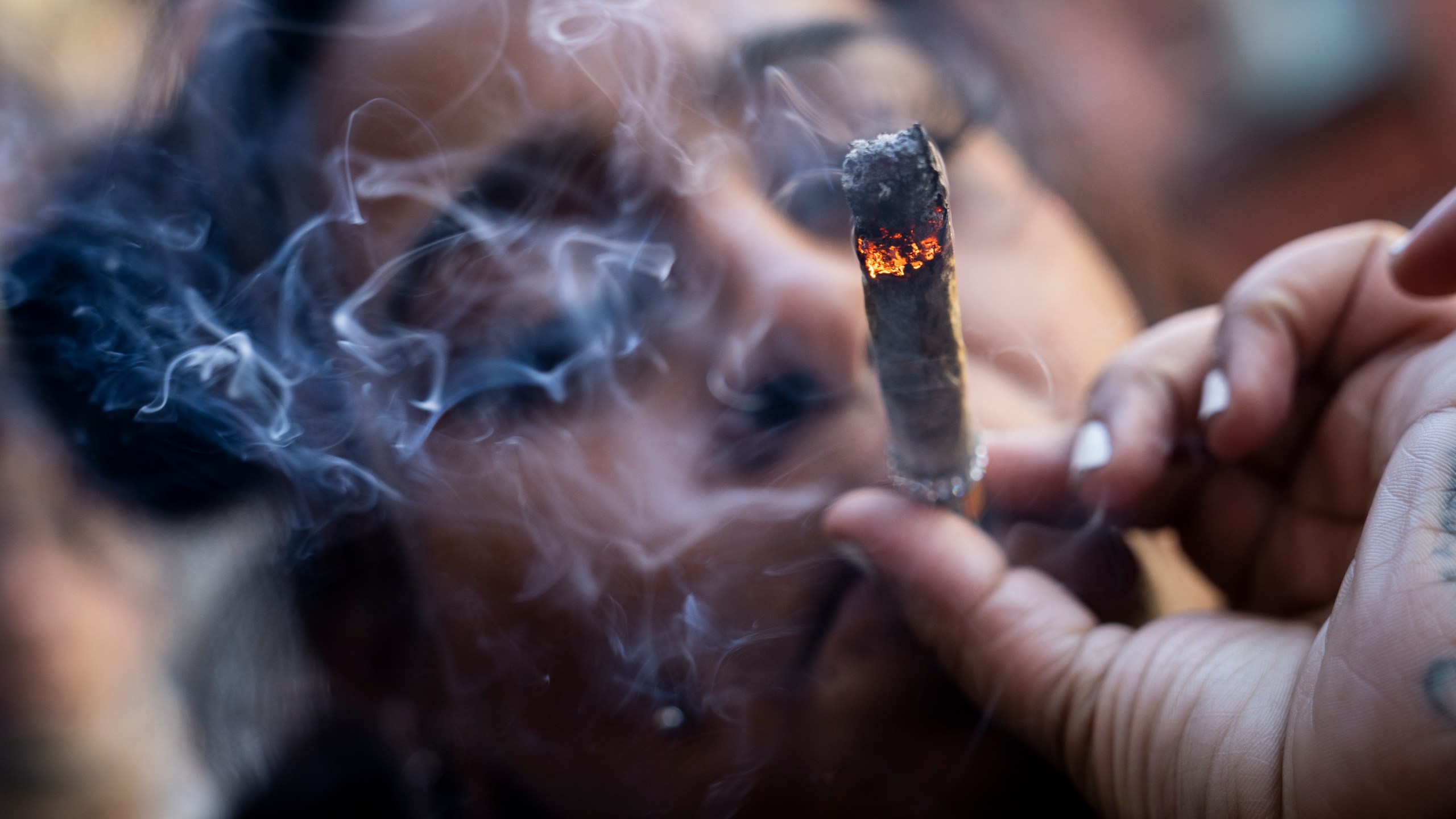 FILE - A person smokes cannabis outside the Smacked "pop up" cannabis dispensary location, Tuesday, Jan. 24, 2023, in New York. (AP Photo/John Minchillo, File)