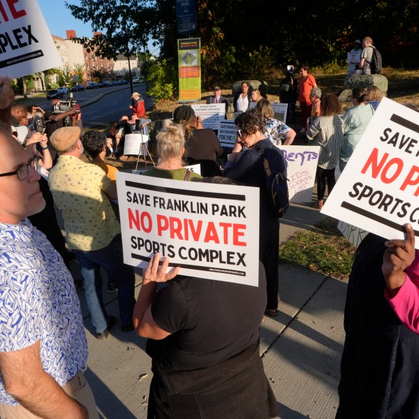 People display placards during a rally held to save White Stadium, Wednesday, Sept. 11, 2024, in Boston. (AP Photo/Steven Senne)