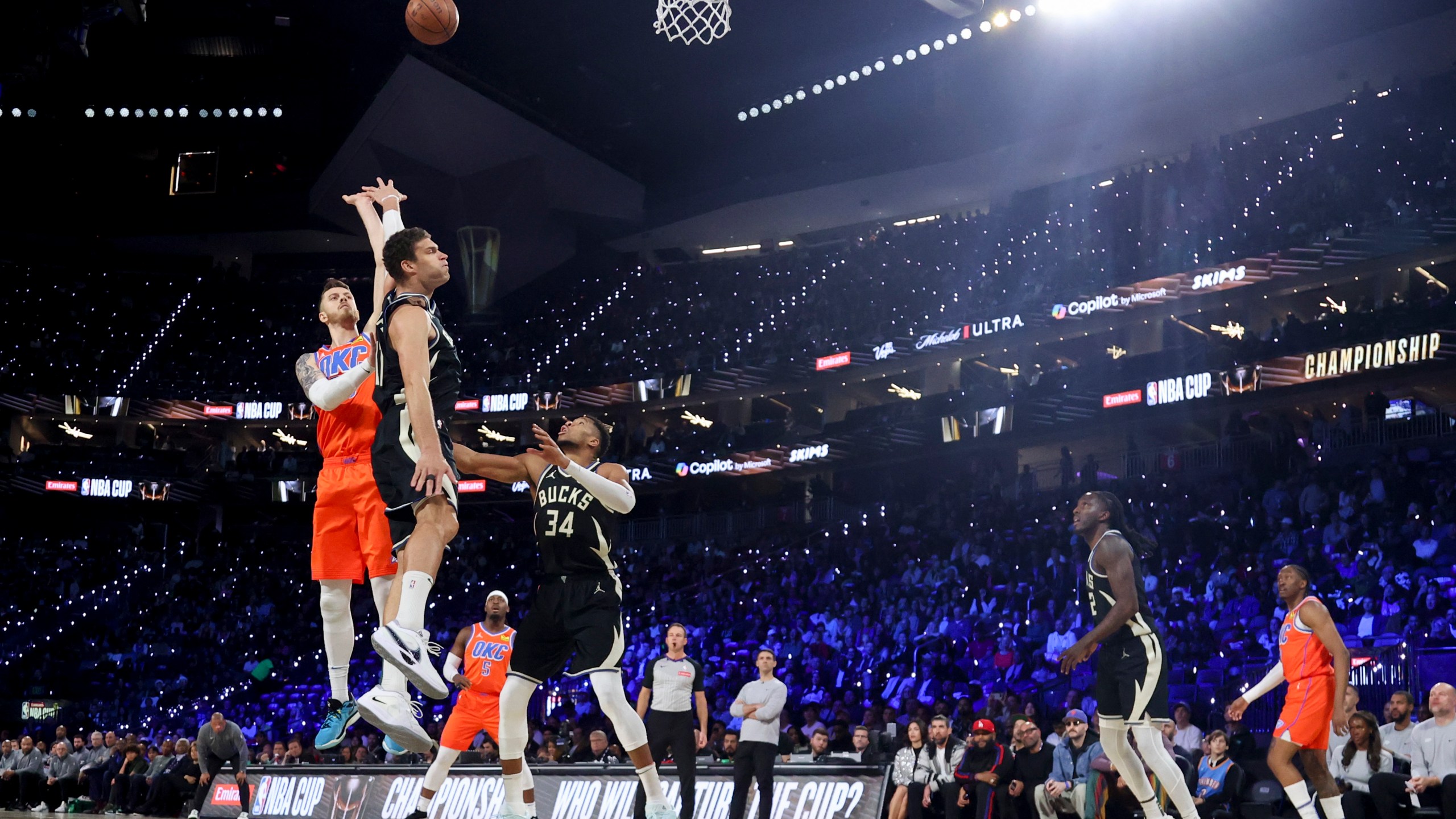 Oklahoma City Thunder center Isaiah Hartenstein (55) shoots against Milwaukee Bucks center Brook Lopez (11) and forward Giannis Antetokounmpo (34) during the first half of the championship game in the NBA Cup basketball tournament Tuesday, Dec. 17, 2024, in Las Vegas. (AP Photo/Ian Maule)