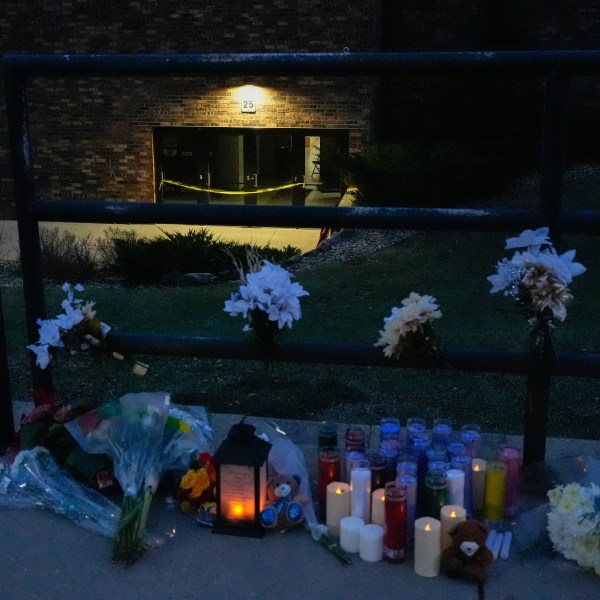 Flowers and candles are placed outside the Abundant Life Christian School Tuesday, Dec. 17, 2024 in Madison, Wis., following a shooting on Monday. (AP Photo/Nam Y. Huh)