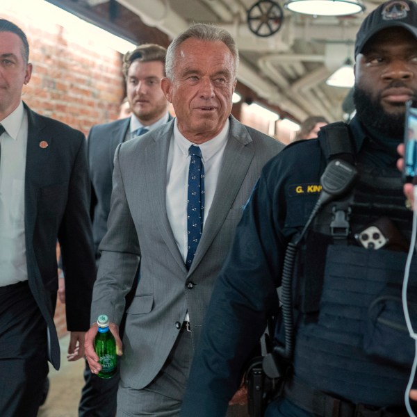 Robert F. Kennedy Jr., President-elect Donald Trump's nominee to be Secretary of Health and Human Services, center, walks to meet with Sen. John Thune, R-S.D. at the Capitol in Washington, Tuesday, Dec. 17, 2024. (AP Photo/Jose Luis Magana)