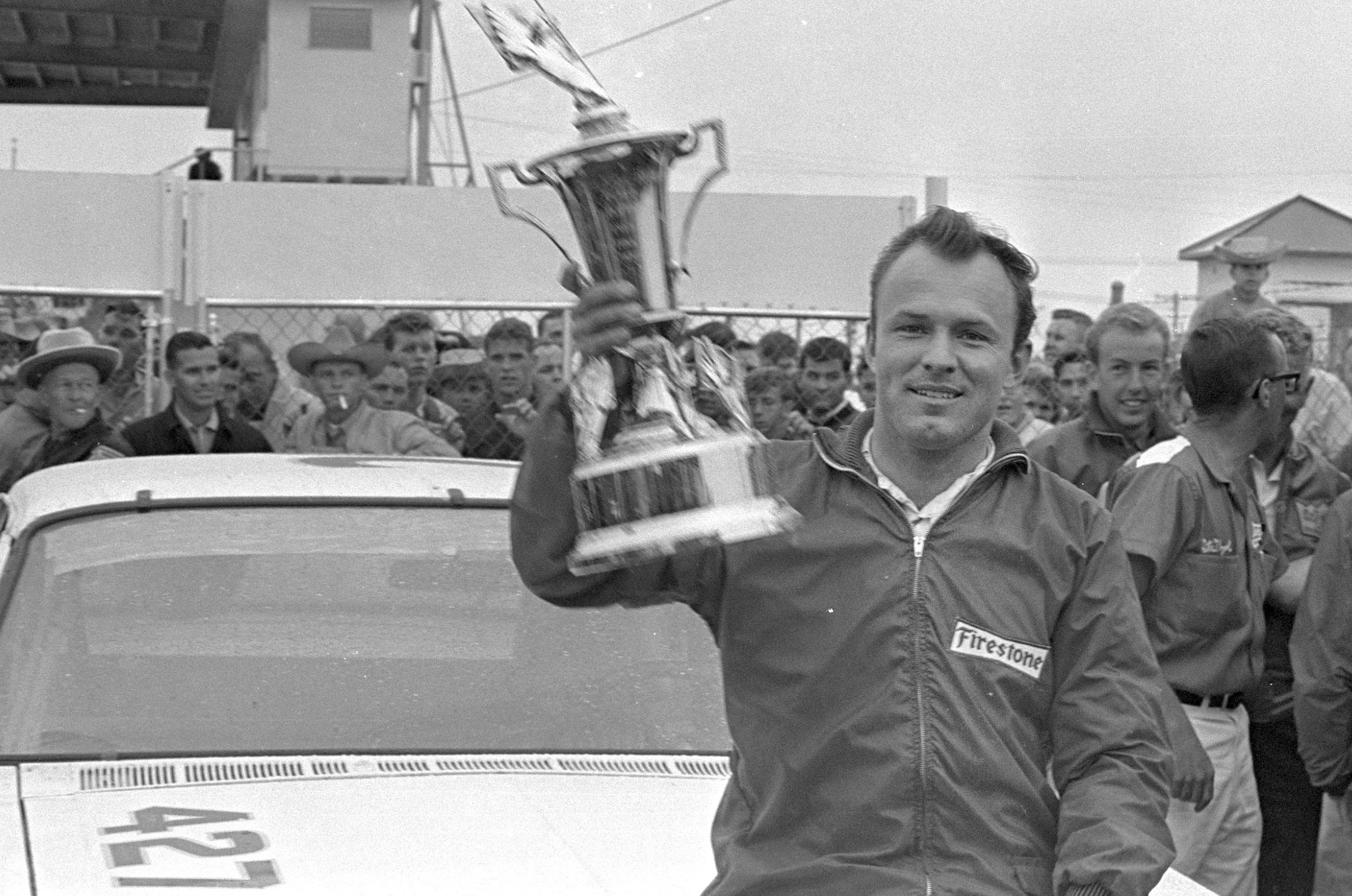 FILE - In this Feb. 14, 1965, file photo, Fred Lorenzen, of Elmhurst, Ill., gives a victory wave after winning the Daytona 500 mile stock car auto race which was halted by rain at the end of 133 laps, in Daytona Beach, Fla. (AP Photo/File)