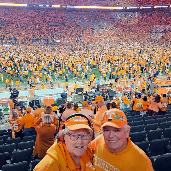 In this image provided by Earl Brown, Brown and his wife Judy pose as Tennessee fans storm the field after the Volunteers defeated Alabama in an NCAA college football game, Saturday, Oct. 19, 2024, in Knoxville, Tenn. (Earl Brown via AP)