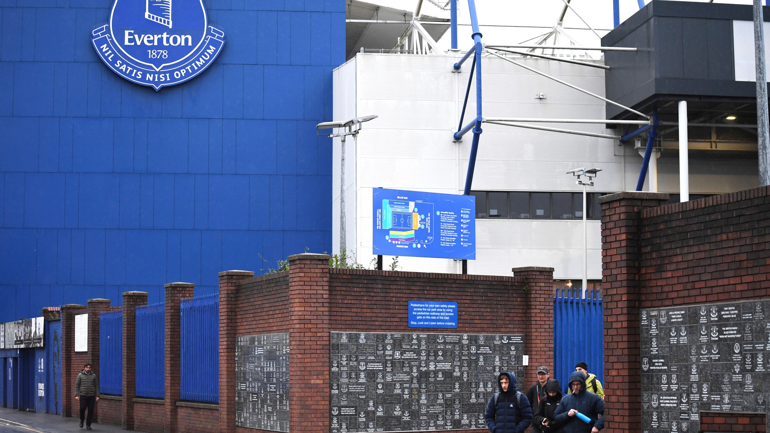 People walk outside Goodison Park as the Premier League soccer match between Everton and Liverpool is called off due to storm Darragh at Goodison Park, in Liverpool, England, Saturday Dec 7, 2024. (AP Photo/Rui Vieira)