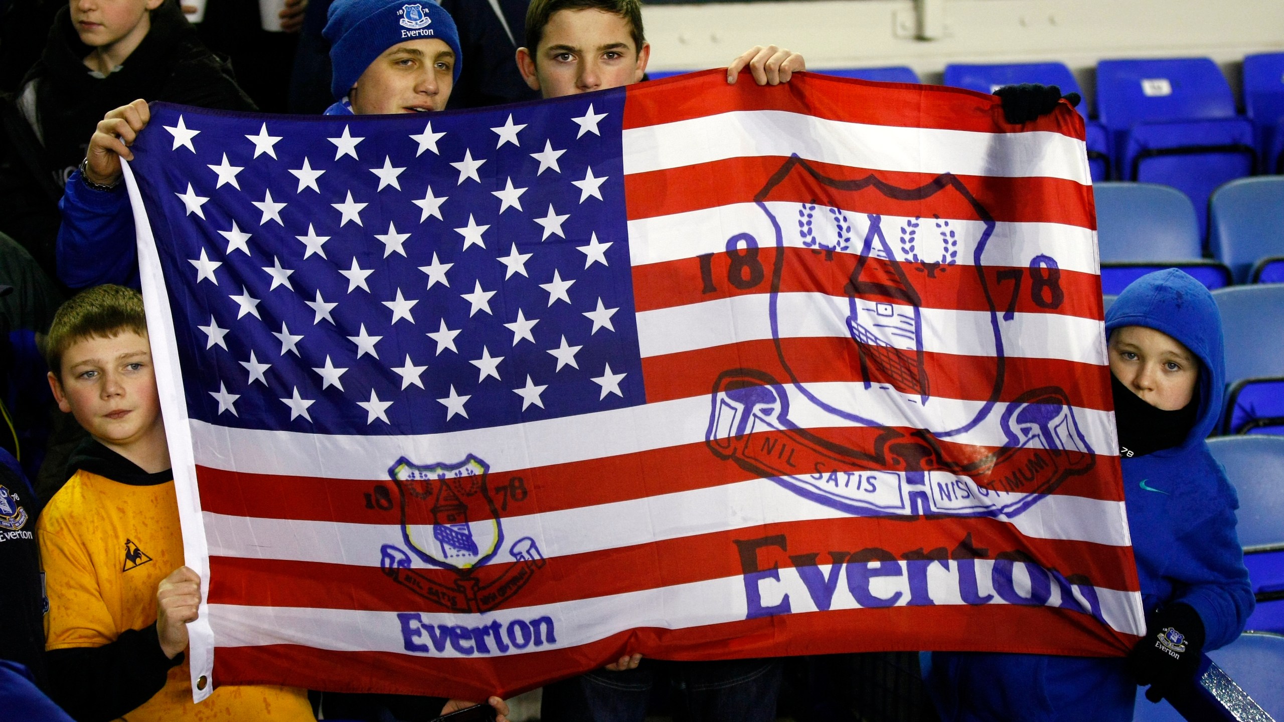 FILE - Fans hold a flag before the English Premier League soccer match between Everton and Bolton at Goodison Park, Liverpool, England, Wednesday Jan. 4, 2012. (AP Photo/Tim Hales, File)