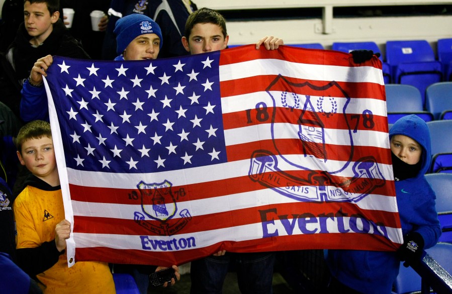 FILE - Fans hold a flag before the English Premier League soccer match between Everton and Bolton at Goodison Park, Liverpool, England, Wednesday Jan. 4, 2012. (AP Photo/Tim Hales, File)