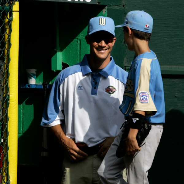 FILE - Chandler Ariz., coach Clay Bellinger, left, smiles at his son and Arizona player Cody Bellinger as they come into the dugout in the third inning against Salisbury, Md., during the 2007 Little League World Series pool play in South Williamsport, Pa., on Saturday, Aug. 18, 2007. (AP Photo/Carolyn Kaster, File)