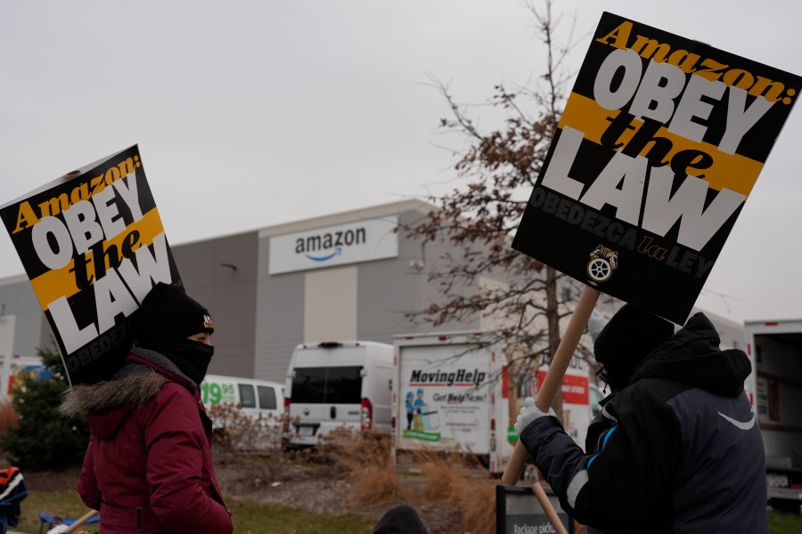 Strikers hold signs during a strike at Skokie (DIL7) Amazon Delivery station in Skokie, Ill., Thursday, Dec. 19, 2024. (AP Photo/Nam Y. Huh)