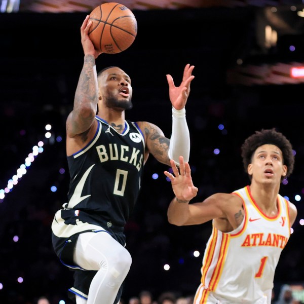 Milwaukee Bucks guard Damian Lillard (0) shoots against Atlanta Hawks forward Jalen Johnson (1) during the second half of a semifinal game in the NBA Cup basketball tournament Saturday, Dec. 14, 2024, in Las Vegas. (AP Photo/Ian Maule)