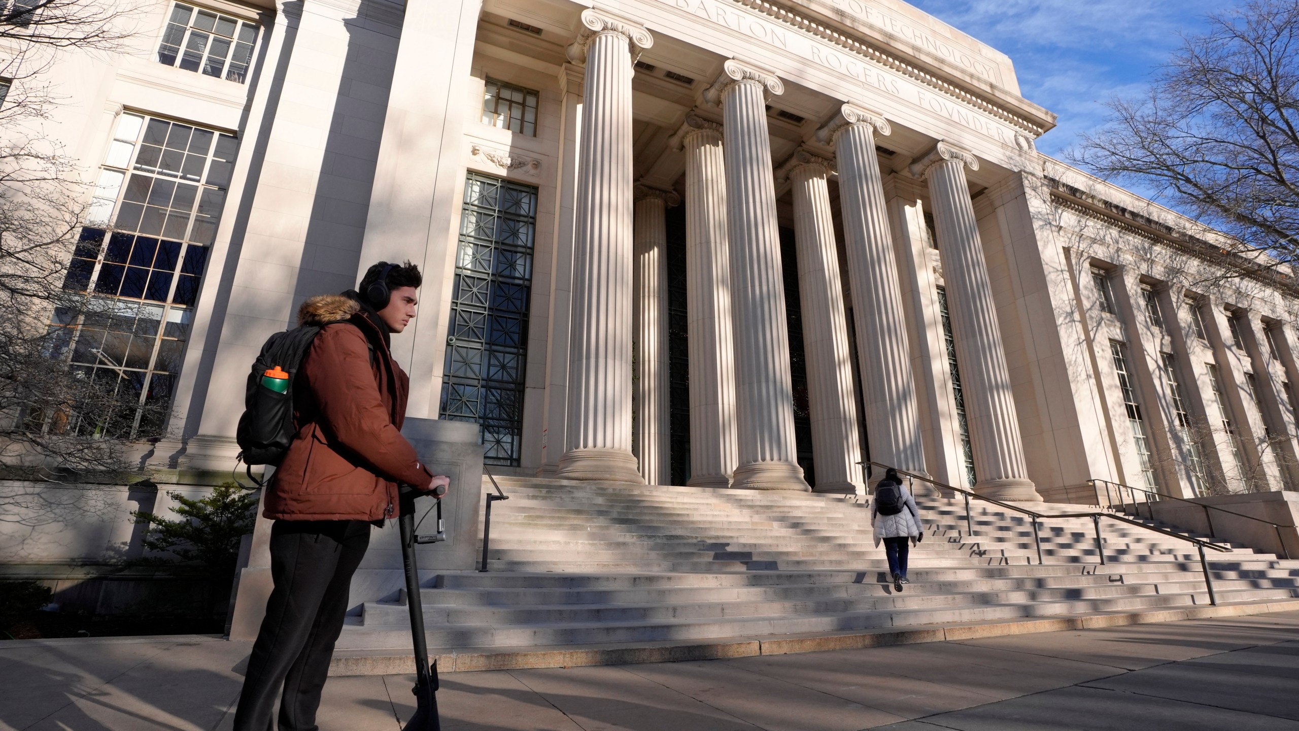 A person rides a scooter, Tuesday, Dec. 17, 2024, near an entrance to Massachusetts Institute of Technology in Cambridge, Mass. (AP Photo/Steven Senne)