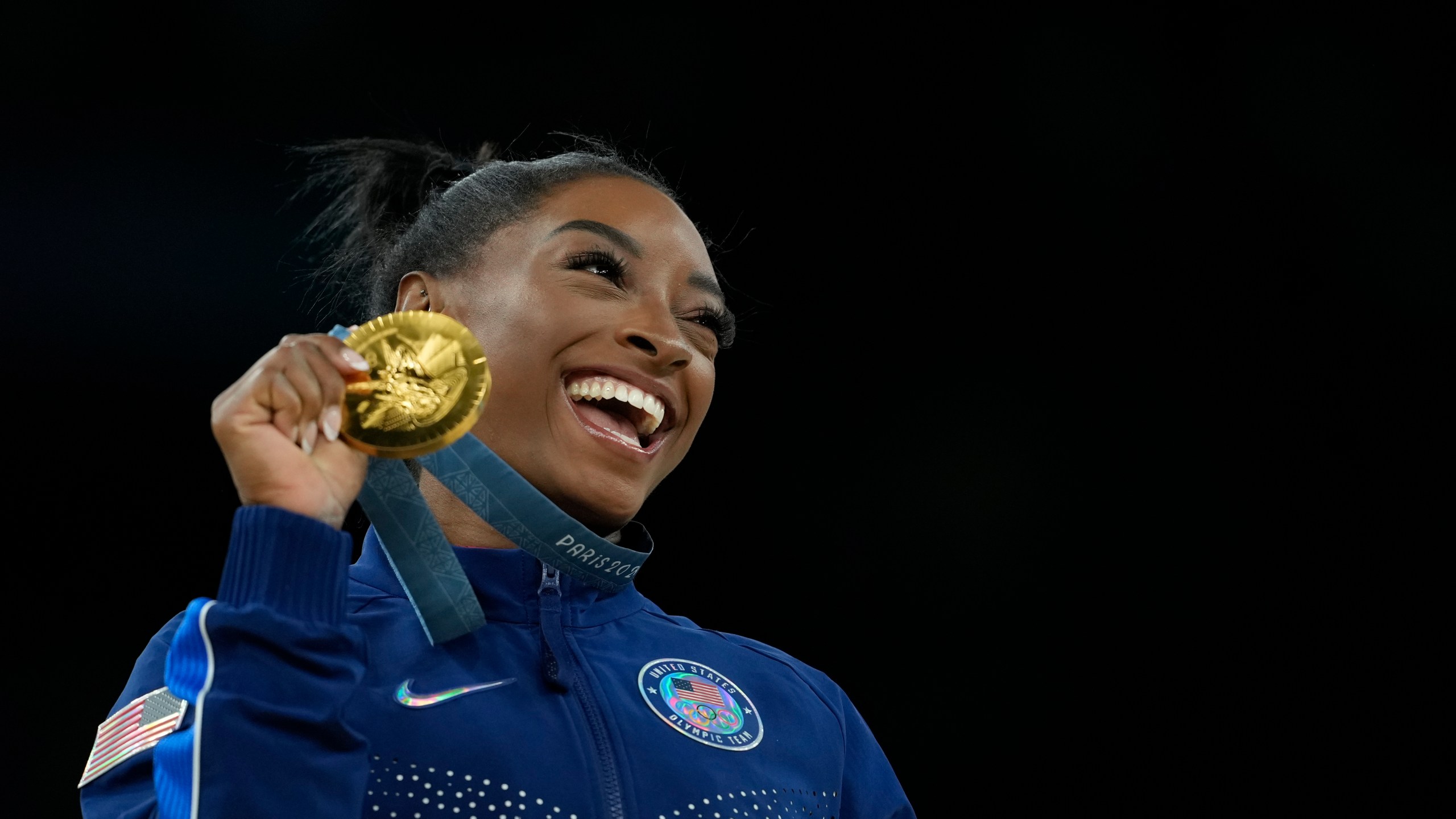 FILE -0 Simone Biles, of the United States, celebrates after winning the gold medal at the medal ceremony during the women's artistic gymnastics individual vault finals at Bercy Arena at the 2024 Summer Olympics, Saturday, Aug. 3, 2024, in Paris, France. (AP Photo/Francisco Seco, File)