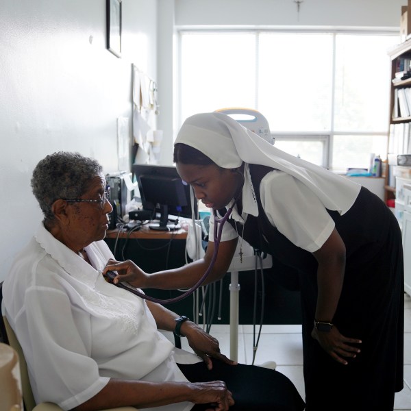 Sister Seyram Mary Adzokpa, right, listens to Sister Clara Mae Jackson's heart in the motherhouse of the Sisters of the Holy Family in New Orleans, Tuesday, June 25, 2024. (AP Photo/Jessie Wardarski)