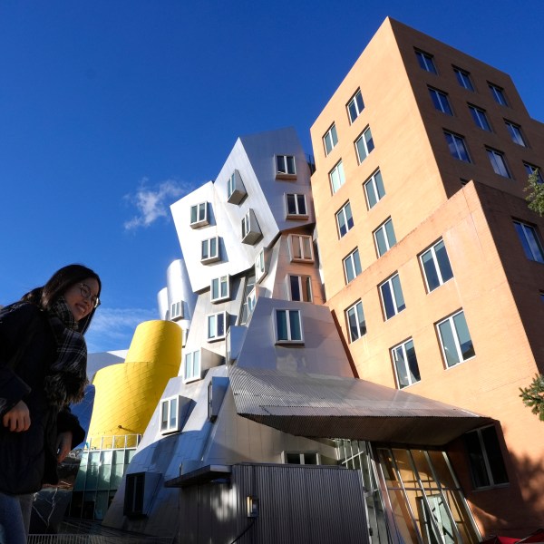 A person walks near buildings, Tuesday, Dec. 17, 2024, on the campus of Massachusetts Institute of Technology in Cambridge, Mass. (AP Photo/Steven Senne)