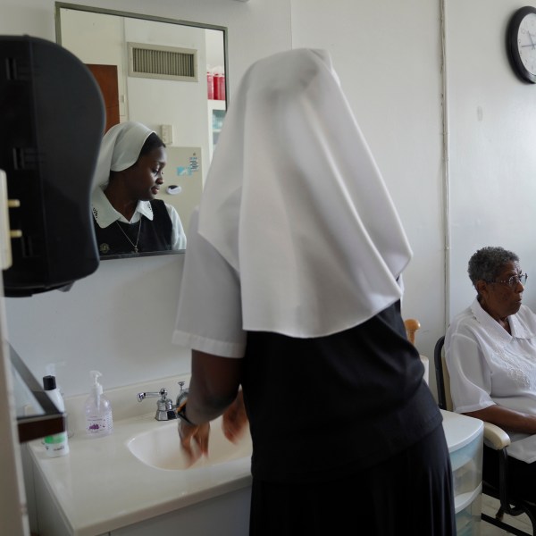 Sister Seyram Mary Adzokpa of the Sisters of the Holy Family cares for Sr. Clara Mae Jackson at the motherhouse in New Orleans, Tuesday, June 25, 2024. (AP Photo/Jessie Wardarski)