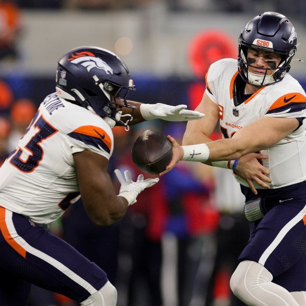 Denver Broncos quarterback Bo Nix, right, hands off to running back Audric Estime (23) during the first half an NFL football game against the Los Angeles Chargers, Thursday, Dec. 19, 2024, in Inglewood, Calif. (AP Photo/Ryan Sun)