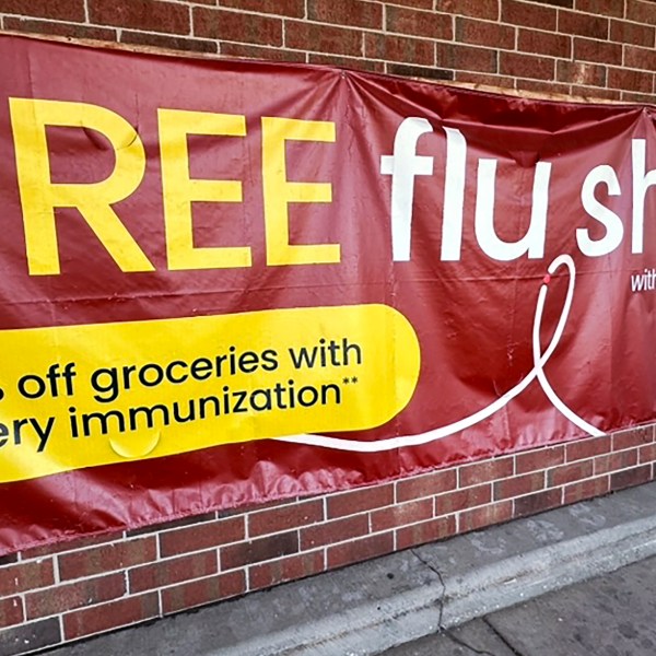 FILE - A sign for flu vaccination is displayed outside of a grocery store in Glenview, Ill., Thursday, Feb. 15, 2024. (AP Photo/Nam Y. Huh, File)