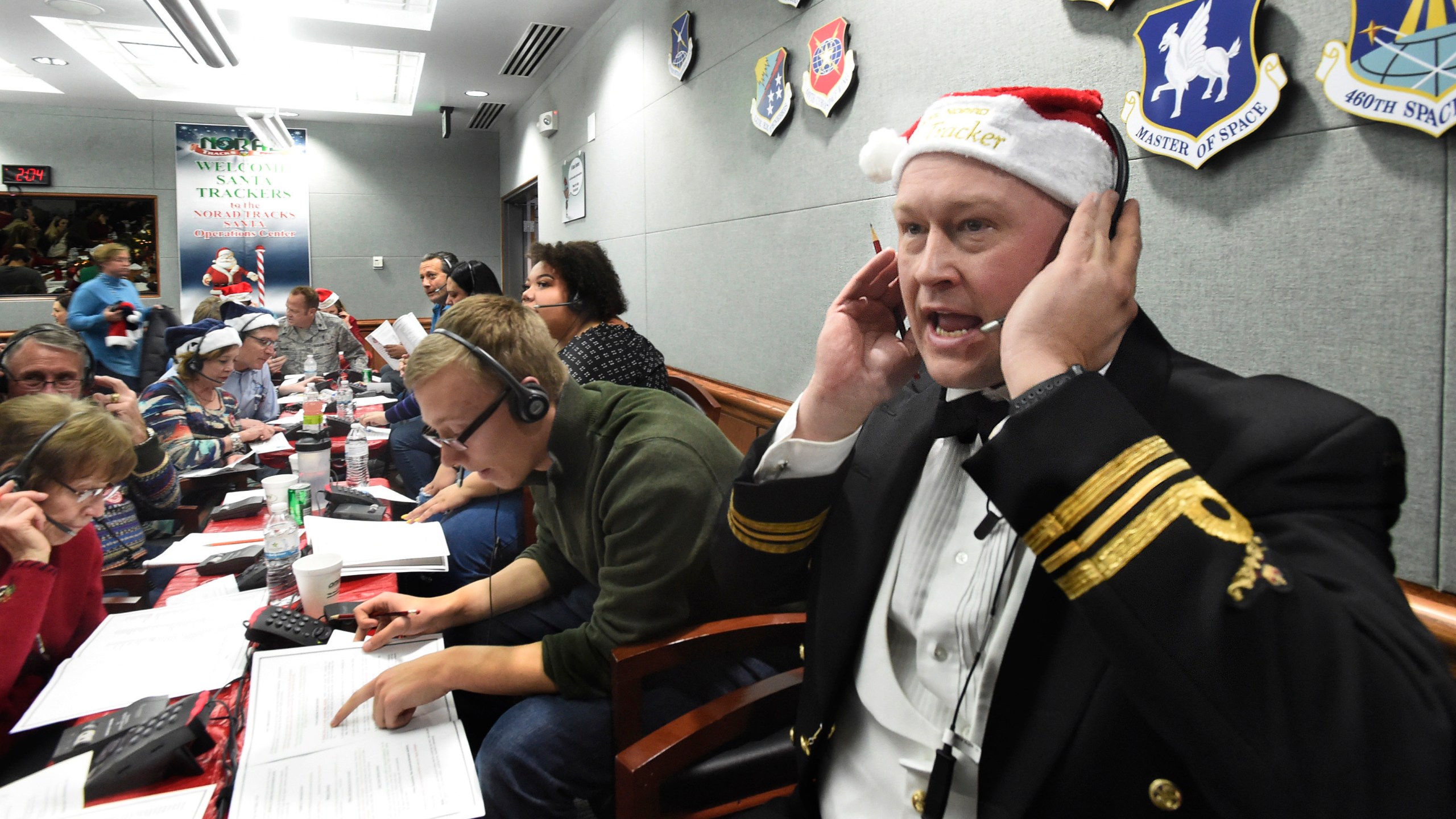 FILE – Canadian Lt. Maj. Chris Hache takes a call while volunteering at the NORAD Tracks Santa center at Peterson Air Force Base in Colorado Springs, Colo., Dec. 24, 2017. (Jerilee Bennett/The Gazette via AP, File)