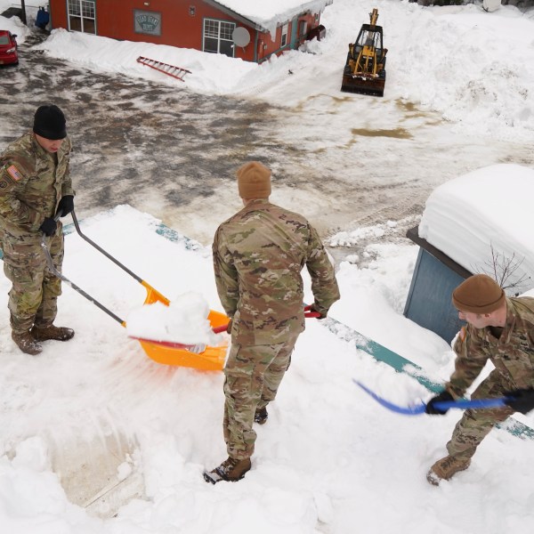 Alaska National Guard soldiers and airmen shovel the roof of a building in Yakutat, Alaska. (Photo by Dana Rosso, U.S. Army National Guard via AP)