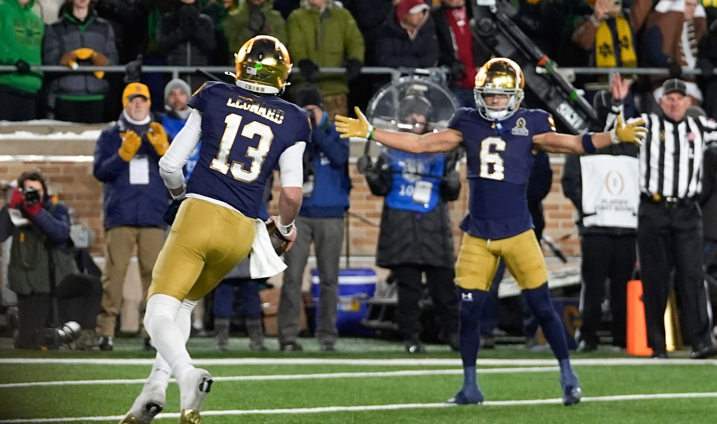 Notre Dame quarterback Riley Leonard (13) celebrates his one-yard touchdown run with Jordan Faison (6) against Indiana during the second half in the first round of the NCAA College Football Playoff, Friday, Dec. 20, 2024, in South Bend, Ind. (AP Photo/Darron Cummings)