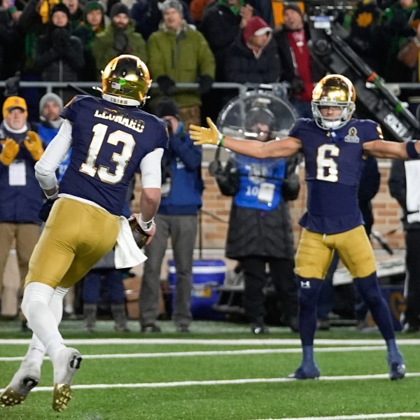 Notre Dame quarterback Riley Leonard (13) celebrates his one-yard touchdown run with Jordan Faison (6) against Indiana during the second half in the first round of the NCAA College Football Playoff, Friday, Dec. 20, 2024, in South Bend, Ind. (AP Photo/Darron Cummings)