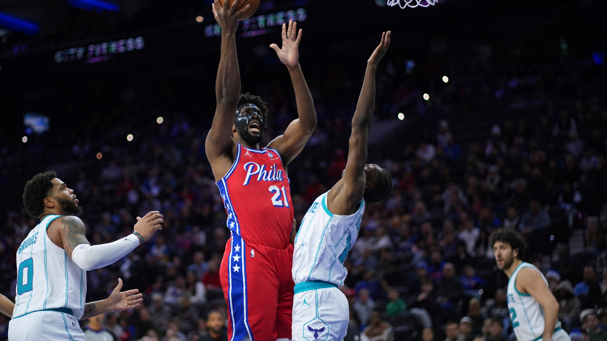 Philadelphia 76ers' Joel Embiid, left, goes up for a shot against Charlotte Hornets' Moussa Diabate during the second half of an NBA basketball game, Friday, Dec. 20, 2024, in Philadelphia. (AP Photo/Matt Slocum)