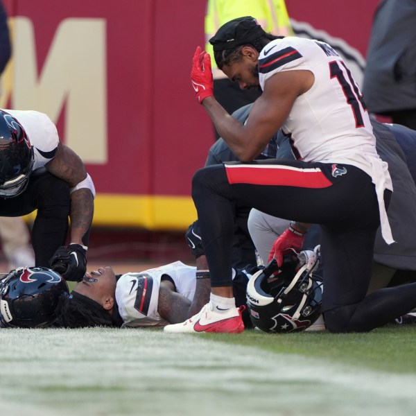 Houston Texans wide receiver Tank Dell is checked on by teammate Jared Wayne, right, after catching a touchdown pass and being injured during the second half of an NFL football game against the Kansas City Chiefs Saturday, Dec. 21, 2024, in Kansas City, Mo. (AP Photo/Charlie Riedel)