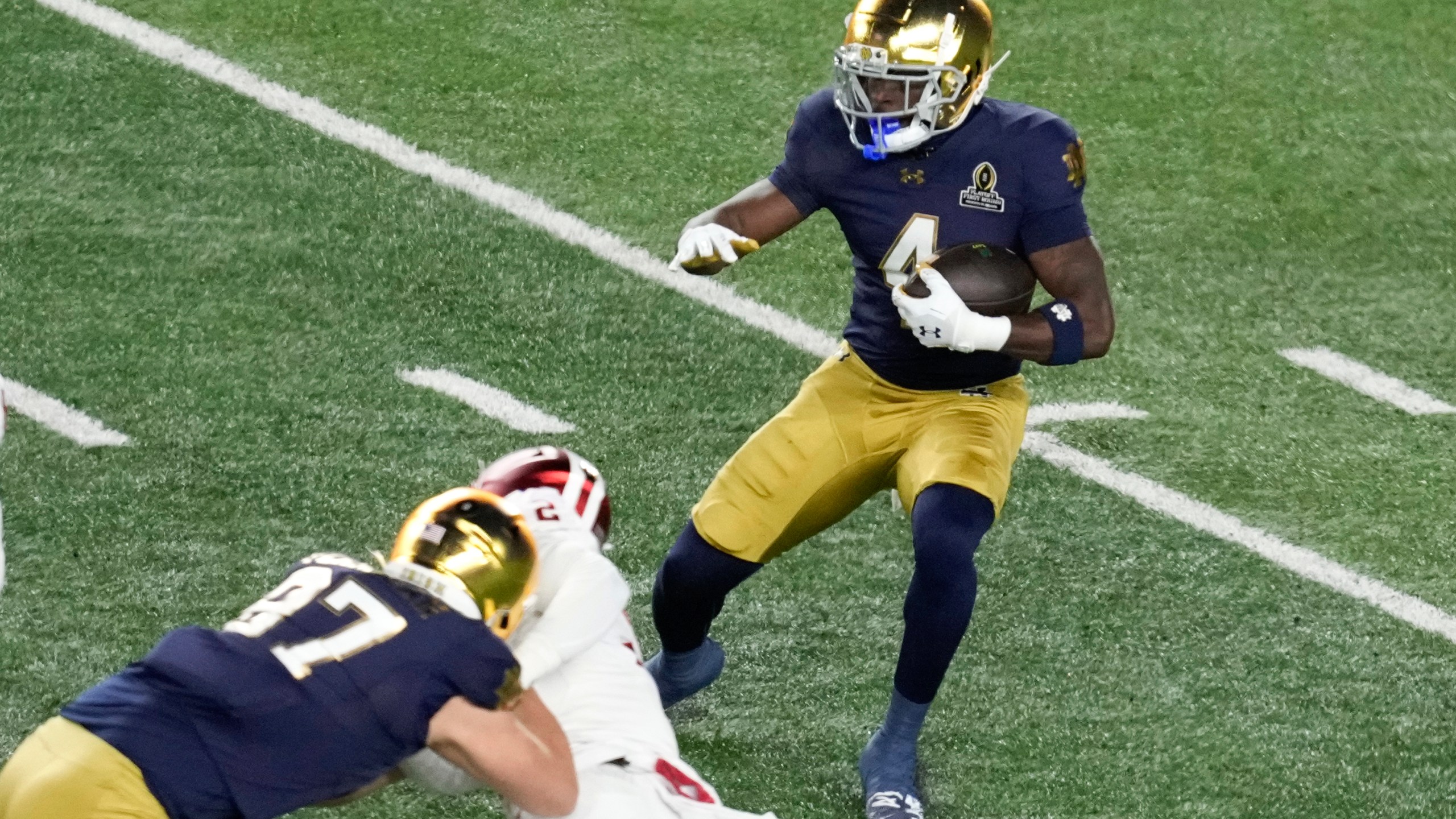 Notre Dame running back Jeremiyah Love (4) runs the ball against Indiana during the first half in the first round of the NCAA College Football Playoff, Friday, Dec. 20, 2024, in South Bend, Ind. (AP Photo/Darron Cummings)