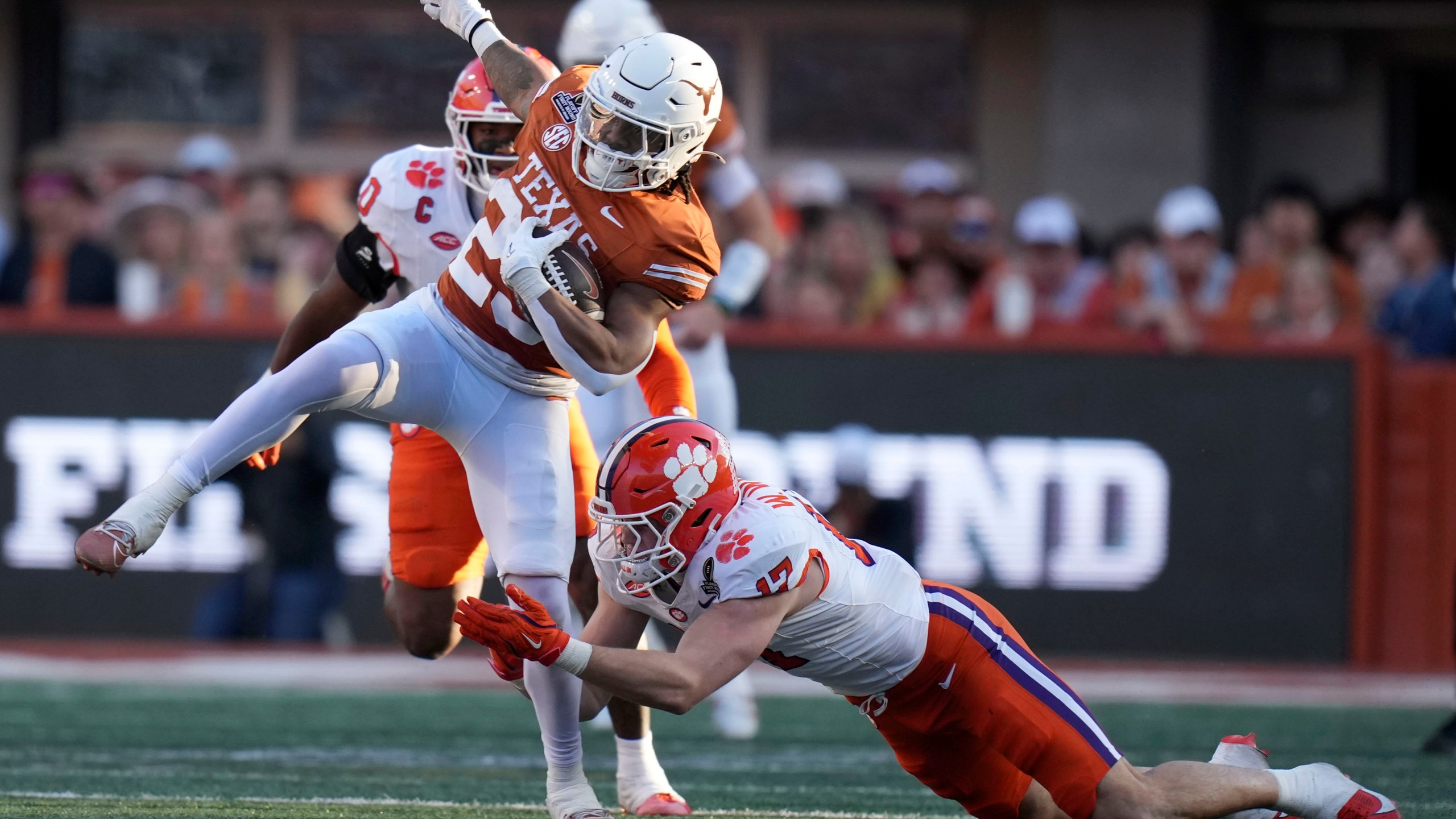 Texas running back Jaydon Blue (23) tries to break a tackle by Clemson linebacker Wade Woodaz (17) during the first half in the first round of the College Football Playoff, Saturday, Dec. 21, 2024, in Austin, Texas. (AP Photo/Eric Gay)