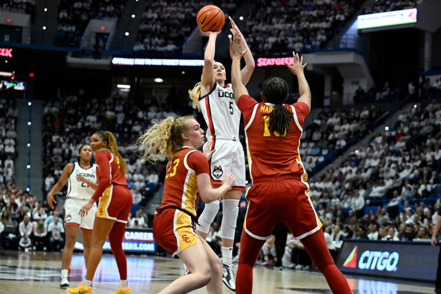 UConn guard Paige Bueckers (5) pulls up for a basket against Southern California guard Avery Howell (23) and center Rayah Marshall (13) in the first half of an NCAA college basketball game, Saturday, Dec. 21, 2024, in Hartford, Conn. (AP Photo/Jessica Hill)