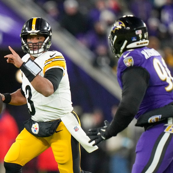 Pittsburgh Steelers quarterback Russell Wilson, left, gestures while scrambling against Baltimore Ravens defensive tackle Broderick Washington during the first half of an NFL football game, Saturday, Dec. 21, 2024, in Baltimore. (AP Photo/Stephanie Scarbrough)