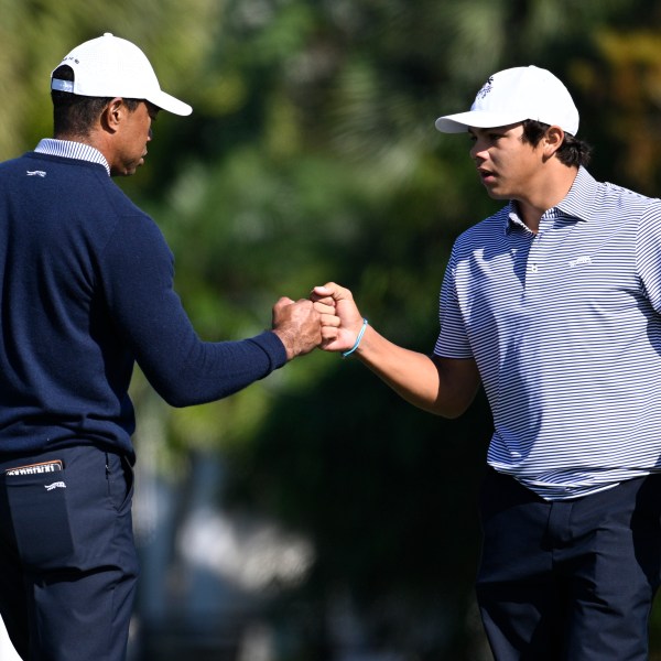 Charlie Woods, right, gets a fist bump from his father, Tiger Woods after making their putt on the fourth green during the first round of the PNC Championship golf tournament, Saturday, Dec. 21, 2024 in Orlando. (AP Photo/Phelan M. Ebenhack)