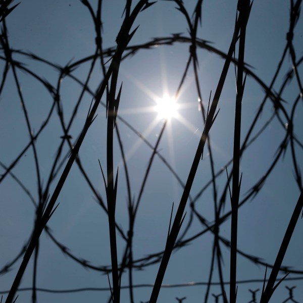 FILE - The sun shines through concertina wire on a fence at the Louisiana State Penitentiary in Angola, La., April 26, 2014. (AP Photo/Gerald Herbert, File)