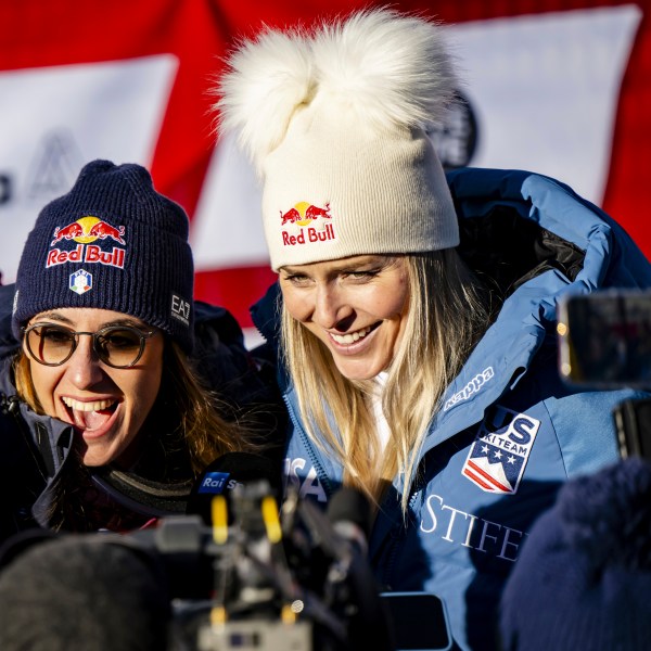 Sofia Goggia of Italy, left, and Lindsey Vonn of United States of America, talk with journalists after completing an alpine ski, women's World Cup super G, in St. Moritz, Switzerland, Saturday, Dec. 21, 2024. (Jean-Christophe Bott/Keystone via AP)