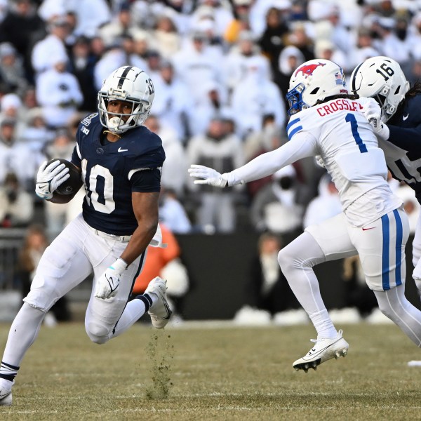 Penn State running back Nicholas Singleton looks to elude SMU safety Brandon Crossley (1) during the first half in the first round of the College Football Playoff, Saturday, Dec. 21, 2024, in State College, Pa. (AP Photo/Barry Reeger)