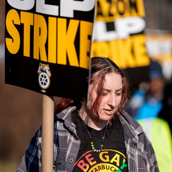 A pro-union demonstrator marches outside an Amazon warehouse, Friday, Dec. 20, 2024, in Alpharetta, Ga. (AP Photo/Mike Stewart)