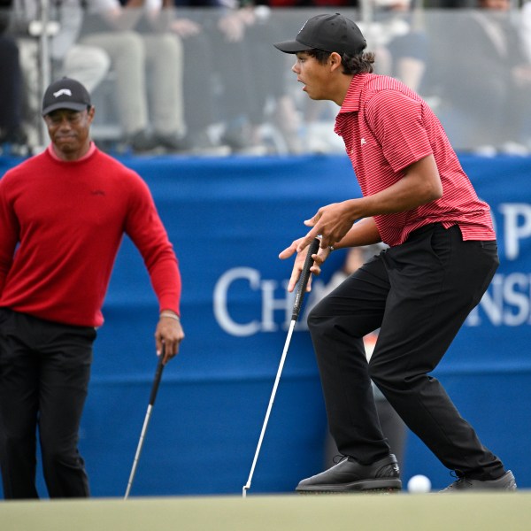 Tiger Woods, left, and Charlie Woods react after missing a putt during a playoff hole on the 18th green to win the PNC Championship golf tournament, Sunday, Dec. 22, 2024, in Orlando, Fla. (AP Photo/Phelan M. Ebenhack)