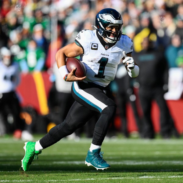 Philadelphia Eagles quarterback Jalen Hurts (1) runs with the ball during the first half of an NFL football game against the Washington Commanders, Sunday, Dec. 22, 2024, in Landover, Md. (AP Photo/Nick Wass)