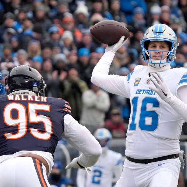 Detroit Lions quarterback Jared Goff passes under pressure from Chicago Bears defensive end DeMarcus Walker during the first half of an NFL football game Sunday, Dec. 22, 2024, in Chicago. (AP Photo/Nam Y. Huh)