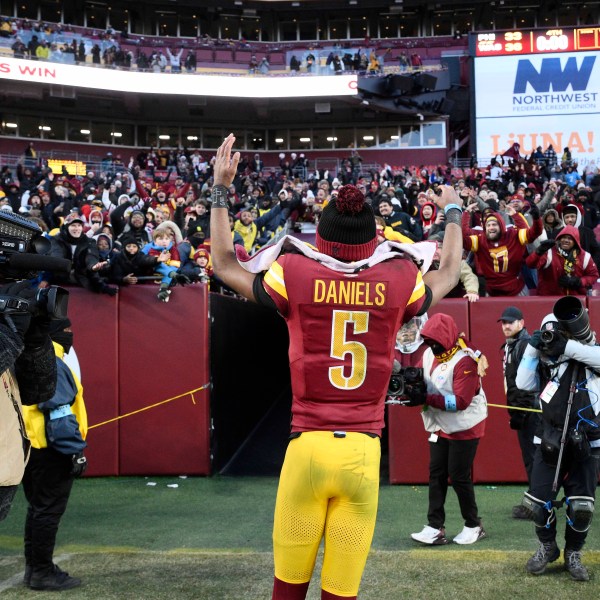 Washington Commanders quarterback Jayden Daniels (5) acknowledges fans as he heads off the field at the end of an NFL football game against the Philadelphia Eagles, Sunday, Dec. 22, 2024, in Landover, Md. (AP Photo/Nick Wass)